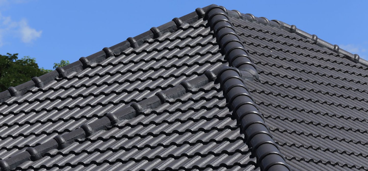 27581082 - black tiles roof on a new house with blue sky